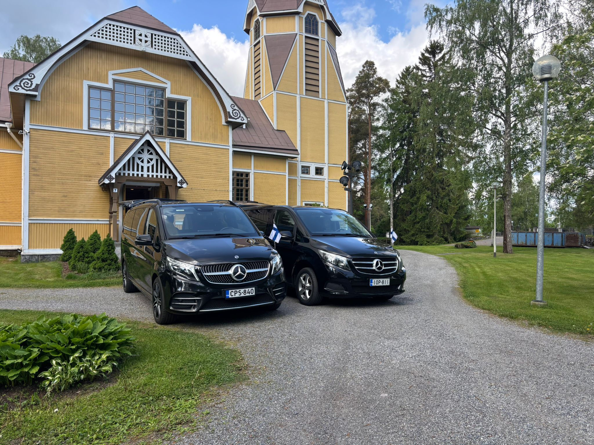 Vainajan kuljetus: Hautaustoimisto Surulinnun autot kirkon edessä